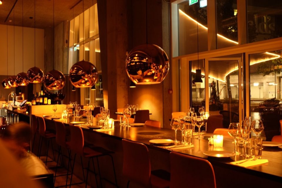 Creative restaurant with big orange circular light fixtures 