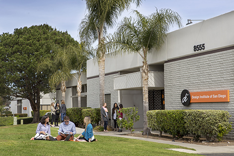 Exterior shot of campus, students walking around, sitting on grass